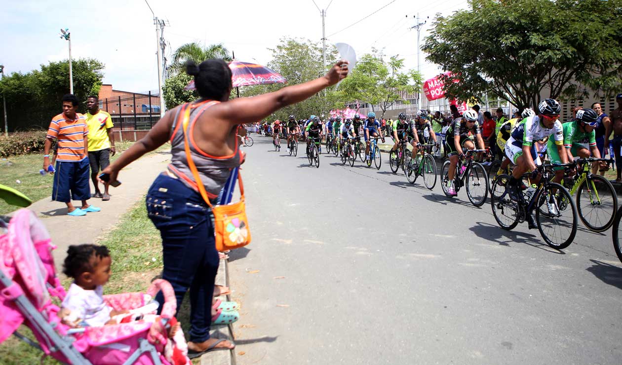 Los aficionados alientan a los corredores en el Clásico RCN en las calles del distrito de Agua Blanca
