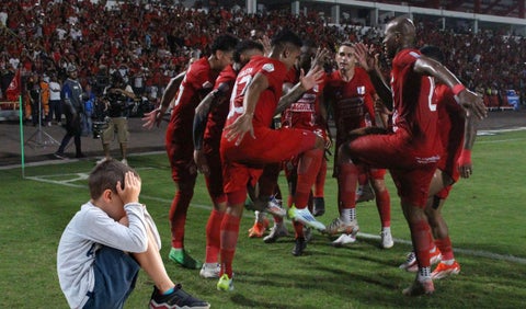 Jugadores de América bailando y un niño llorando