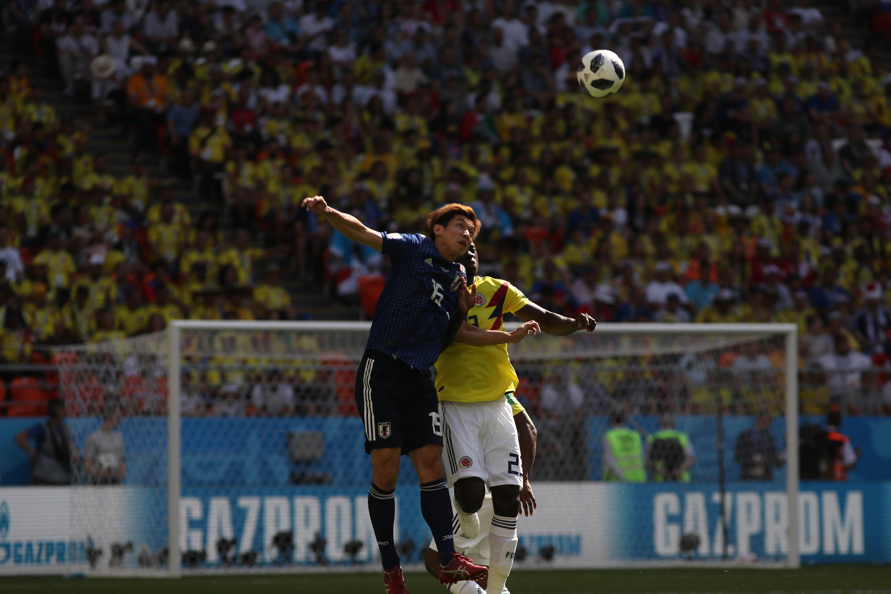 Pelota dividida entre un jugador colombiano y otro japonés durante la primera mitad