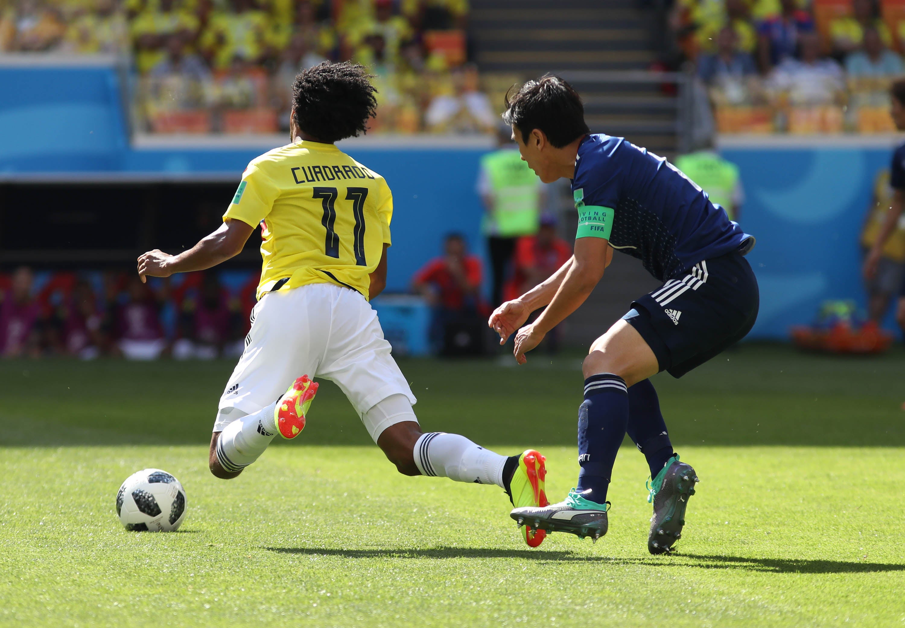 Cuadrado recibiendo una falta de un futbolista japonés