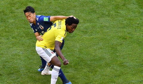 Carlos Sánchez disputando una pelota con su similar de Japón