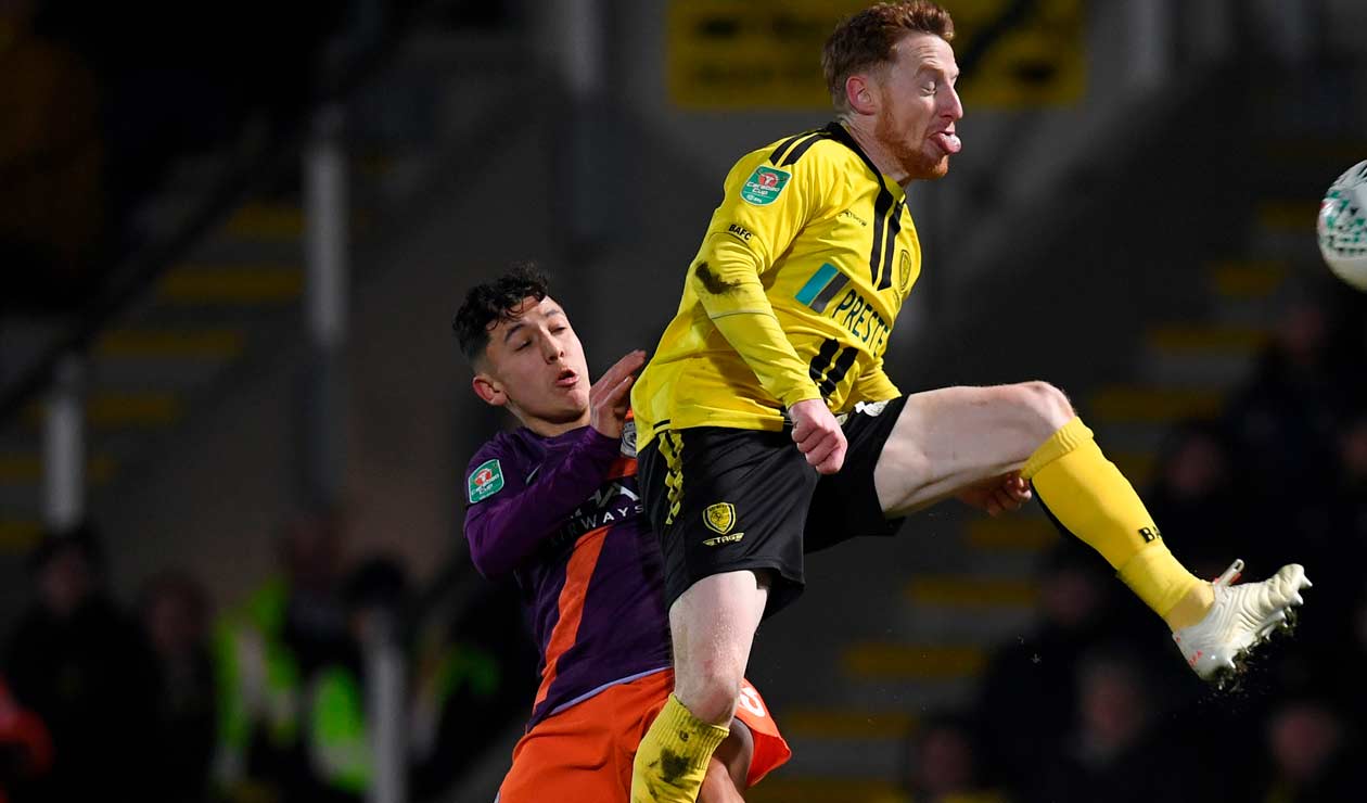 Ian Carlo Poveda lucha por el balón con un jugador del Burton Albion