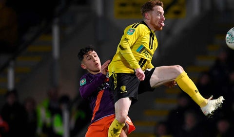 Ian Carlo Poveda lucha por el balón con un jugador del Burton Albion